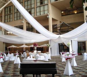 un salón de banquetes con mesas blancas y cortinas blancas en DoubleTree by Hilton St Paul Downtown, en Saint Paul