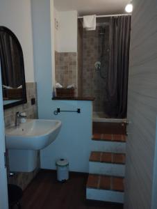 a bathroom with a sink and a shower and a tub at Residenza La Dimora ImPerfetta in Salionze