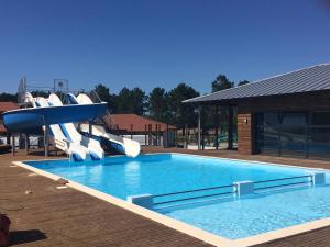 - une piscine avec toboggan dans un complexe dans l'établissement Résidence Néméa le Domaine des Dunes, à Mimizan-Plage