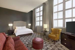 a hotel room with a bed and a couch and a tv at Hampton Inn and Suites New Orleans Convention Center in New Orleans