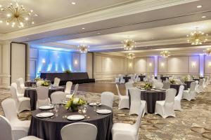 a banquet hall with tables and white chairs and chandeliers at Hampton Inn and Suites New Orleans Convention Center in New Orleans