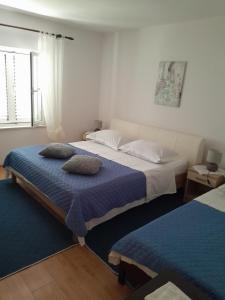 a bedroom with two beds with pillows on them at Apartments Biočić in Korčula