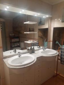 a bathroom with two sinks and a large mirror at Benedita's House in Capinha