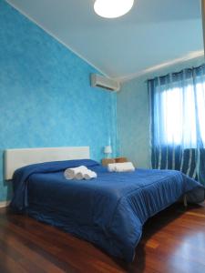 una camera blu con un letto e asciugamani di Villetta Camastra a Misterbianco