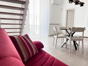 un soggiorno con divano rosa e tavolo di TornaRé a Trani