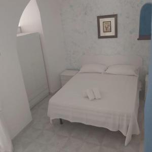 sypialnia z białym łóżkiem i obrazem na ścianie w obiekcie Casa della Nonna w mieście Atrani