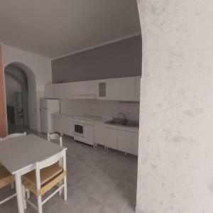 a kitchen with white cabinets and a table in it at Casa della Nonna in Atrani