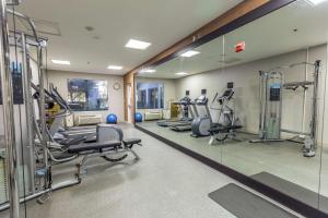 un gimnasio con varias cintas de correr y espejos en Hilton Garden Inn Fairfield en Fairfield