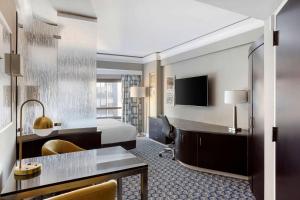 une chambre d'hôtel avec un lit et une télévision dans l'établissement Hilton Club New York, à New York