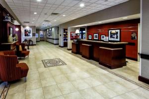 a lobby with a bar and chairs in a building at Hampton Inn & Suites Staten Island in Staten Island