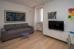 a living room with a couch and a flat screen tv at Blue Home Tellaro in Tellaro
