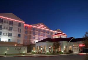 ein Hotelgebäude mit einem rot beleuchteten Schild darauf in der Unterkunft Hilton Garden Inn Oklahoma City Midtown in Oklahoma City