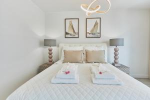 a bedroom with a white bed with towels on it at Wave Prestige Sea View - SPA&Pools in Międzyzdroje