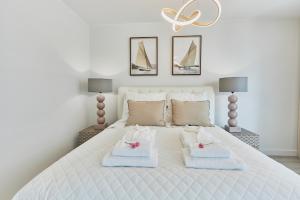 a bedroom with a white bed with towels on it at Wave Prestige Sea View - SPA&Pools in Międzyzdroje +31 photos