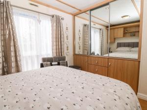a bedroom with a large bed and a mirror at Gwel Y Môr in Caernarfon