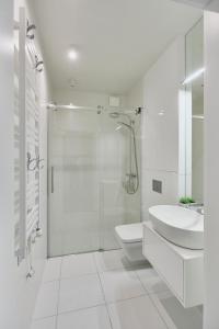 a bathroom with a shower and a toilet and a sink at Wave Prestige Sea View - SPA&Pools in Międzyzdroje