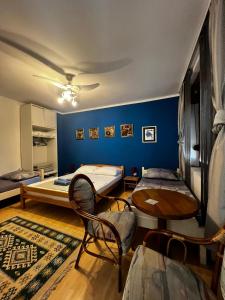 a room with two beds and a table and chairs at Apartments Azra in Mostar