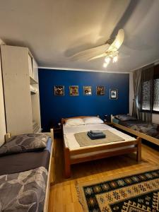 a bedroom with two beds and a blue wall at Apartments Azra in Mostar