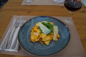 a blue plate of food and a glass of wine at Casa M Vineyard in Chianciano Terme