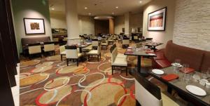 オンタリオにあるEmbassy Suites Ontario - Airportのレストラン内のテーブルと椅子のあるダイニングルーム