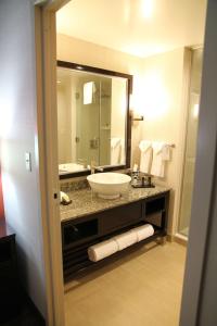 a bathroom with a sink and a large mirror at Embassy Suites Ontario - Airport in Ontario