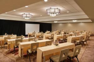uma sala de conferências com mesas, cadeiras e lustres em DoubleTree by Hilton Irvine Spectrum em Irvine