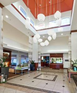 an office lobby with a large ceiling with chandeliers at Hilton Garden Inn Ontario Rancho Cucamonga in Rancho Cucamonga