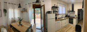 a kitchen with a table and a white refrigerator at Can Marasí in Lloret de Mar