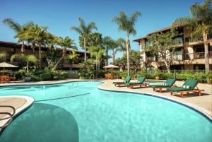 a swimming pool with lounge chairs and a resort at DoubleTree by Hilton Claremont in Claremont