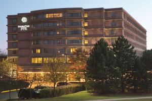 un gran edificio con coches estacionados frente a él en DoubleTree Suites by Hilton Hotel & Conference Center Chicago-Downers Grove en Downers Grove