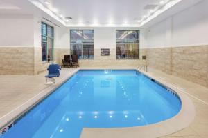 een groot zwembad met blauw water in een gebouw bij Hilton Garden Inn Evanston in Evanston