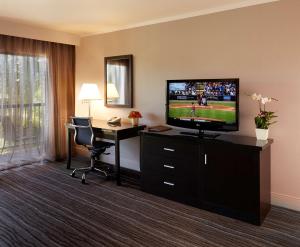 a hotel room with a television and a desk with a computer at DoubleTree by Hilton Claremont in Claremont