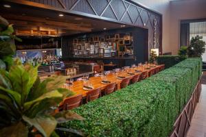 a restaurant with a long table with green plants at DoubleTree Suites by Hilton Hotel & Conference Center Chicago-Downers Grove in Downers Grove