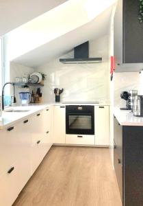 a kitchen with white cabinets and a black oven at Penthouse Furnas in Furnas