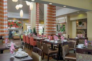 ein Esszimmer mit Tischen und Stühlen in einem Restaurant in der Unterkunft Hilton Garden Inn Newport News in Newport News