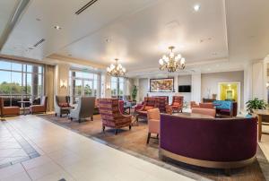 hol hotelu z krzesłami i stołami w obiekcie Hilton Garden Inn Suffolk Riverfront w mieście Suffolk
