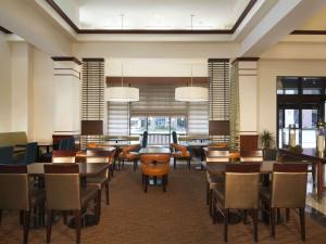 a restaurant with tables and chairs in a room at Hilton Garden Inn Virginia Beach Town Center in Virginia Beach