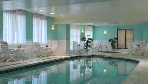 uma piscina num hotel com cadeiras e mesas em Hilton Garden Inn Virginia Beach Town Center em Virginia Beach
