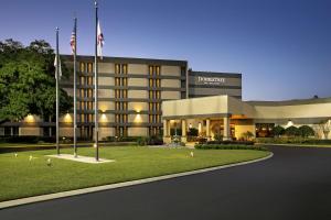 un edificio con dos banderas delante en DoubleTree by Hilton Orlando East - UCF Area, en Orlando