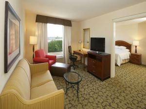 a hotel room with a couch and a bed and a television at Hilton Garden Inn Virginia Beach Town Center in Virginia Beach