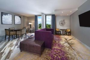 a living room with a purple couch and a table at DoubleTree by Hilton Orlando East - UCF Area in Orlando