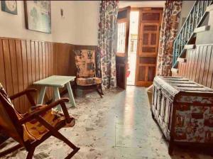 ein Wohnzimmer mit einem Tisch und einem Stuhl in der Unterkunft Casa El Cerro in Villacarrillo