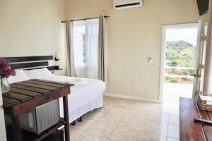 sypialnia z łóżkiem i przesuwnymi szklanymi drzwiami w obiekcie Ocean View Hotel and Restaurant w mieście Roatán