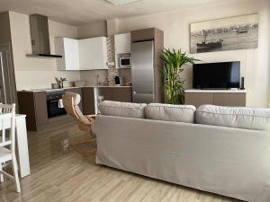a living room with a couch and a kitchen at Cal Xambu in Cambrils