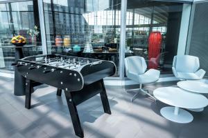 - un baby-foot dans une salle avec 2 chaises et une table dans l'établissement Hilton Paris La Défense, à Puteaux