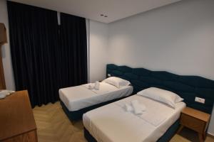 Giường trong phòng chung tại Agimi Hotel