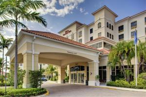 a rendering of the front of a hotel with palm trees at Hilton Garden Inn Palm Beach Gardens in Palm Beach Gardens