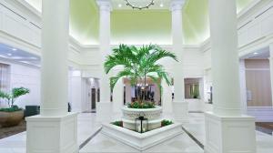 a lobby with a palm tree in a fountain at Hilton Garden Inn Palm Beach Gardens in Palm Beach Gardens