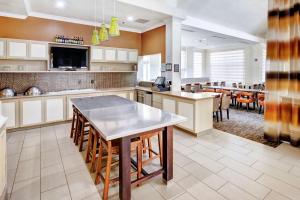 a large kitchen with a table and some chairs at Hilton Garden Inn Portland Airport in Portland