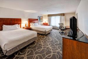 a hotel room with two beds and a flat screen tv at Hilton Garden Inn Portland Airport in Portland +18 photos